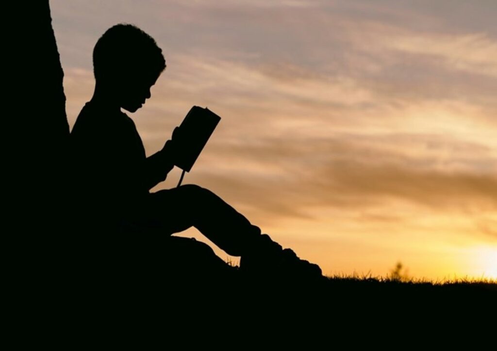 Illustration syndrome d'Asperger (TSA) : enfant isolé qui lit assis contre un arbre.